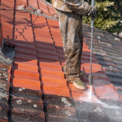 State of roof before and after washing with high pressure. Professional is wearing uniform and using equipment for cleaning.