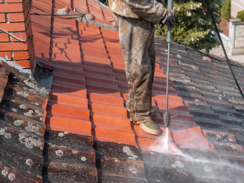 State of roof before and after washing with high pressure. Professional is wearing uniform and using equipment for cleaning.